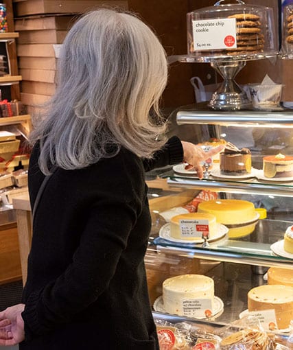 Susan Weiss Berry in a NYC cake shop choosing a cake.